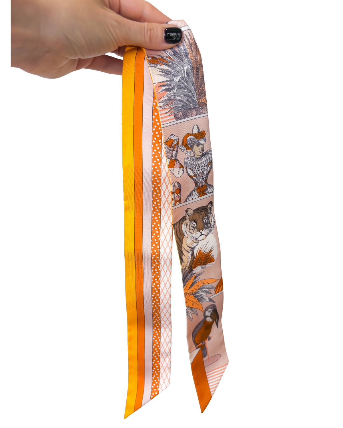 Full-length view of Hermès silk Twilly scarf in Grand Théâtre Nouveau print held up to showcase the slim silk design