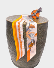 Hermès Grand Théâtre Nouveau silk Twilly scarf in poudre pink and vibrant orange styled over a decorative stand