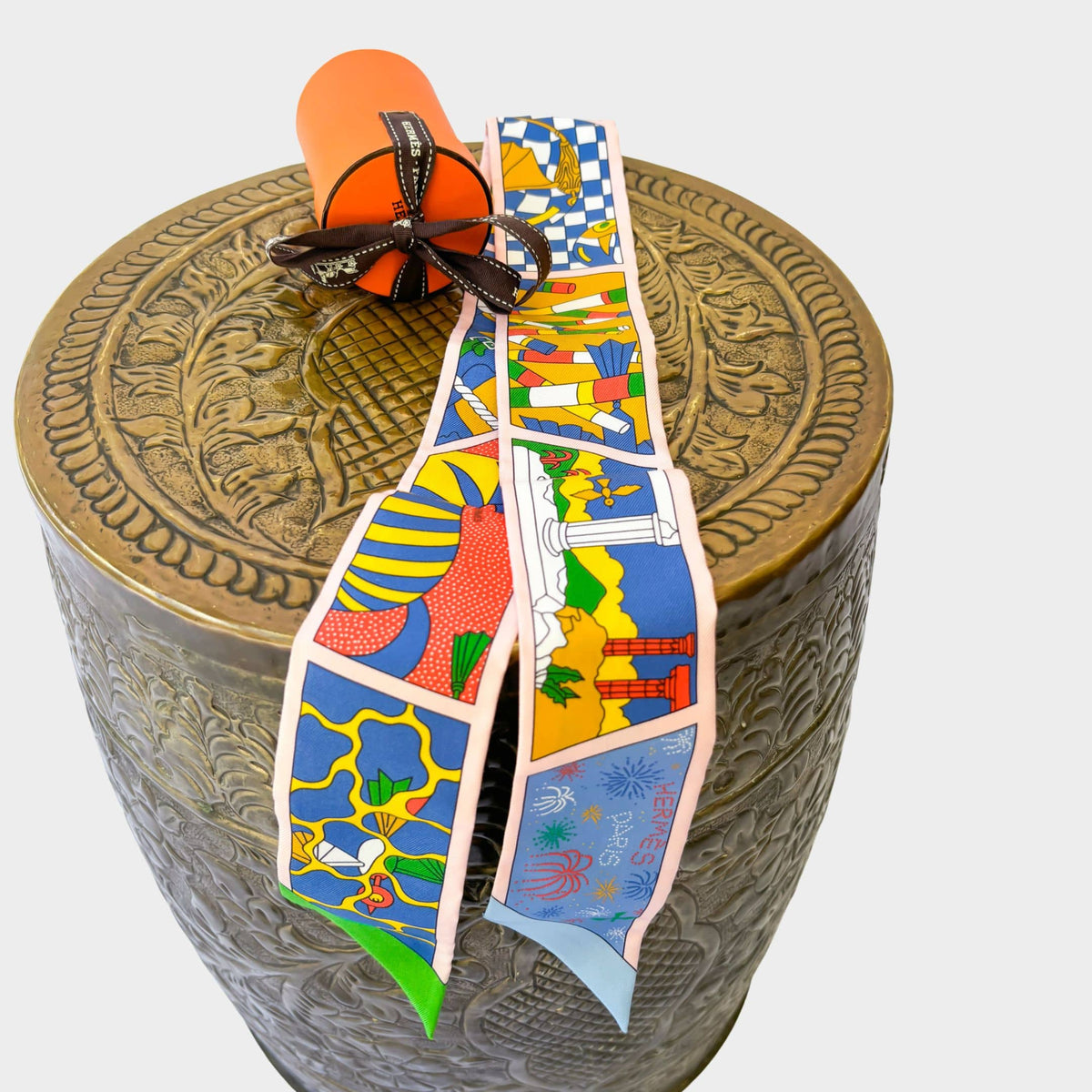 Authentic Hermès Twilly Factory Sweet silk scarf in Blue, Rose, and Mordori, styled elegantly on a display stand.