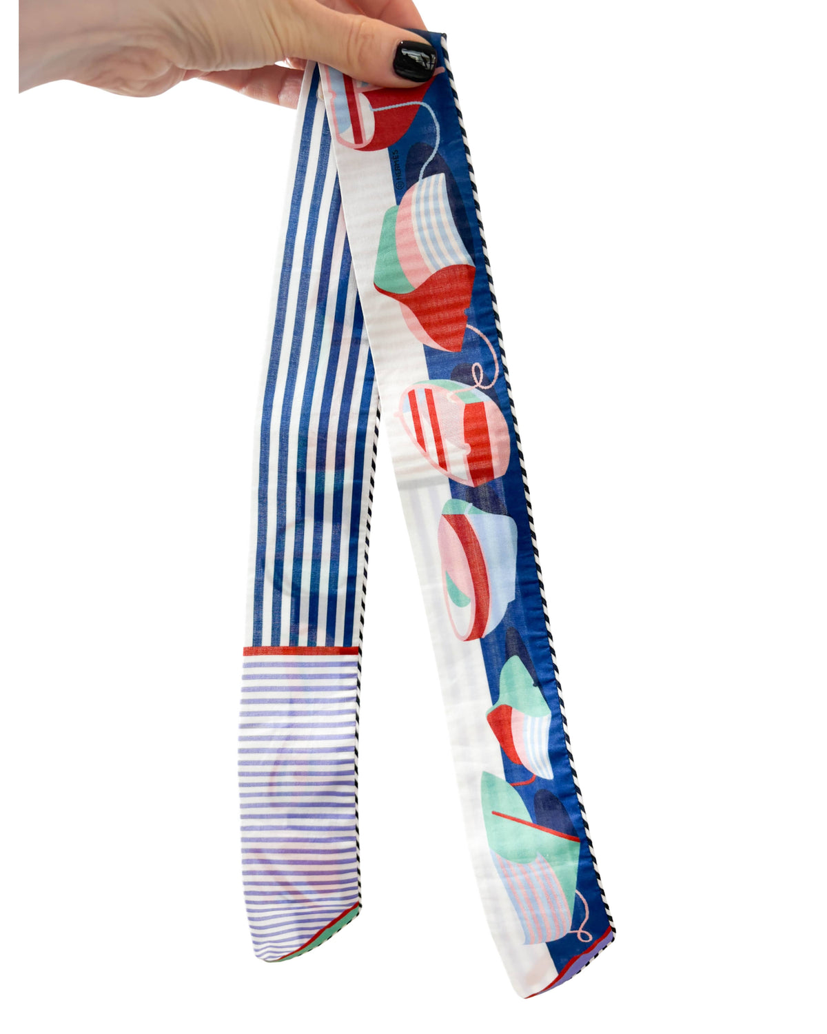 Full-length view of Hermès Thalassa cotton Twilly ribbon held up to showcase the complete maritime stripe and motif design