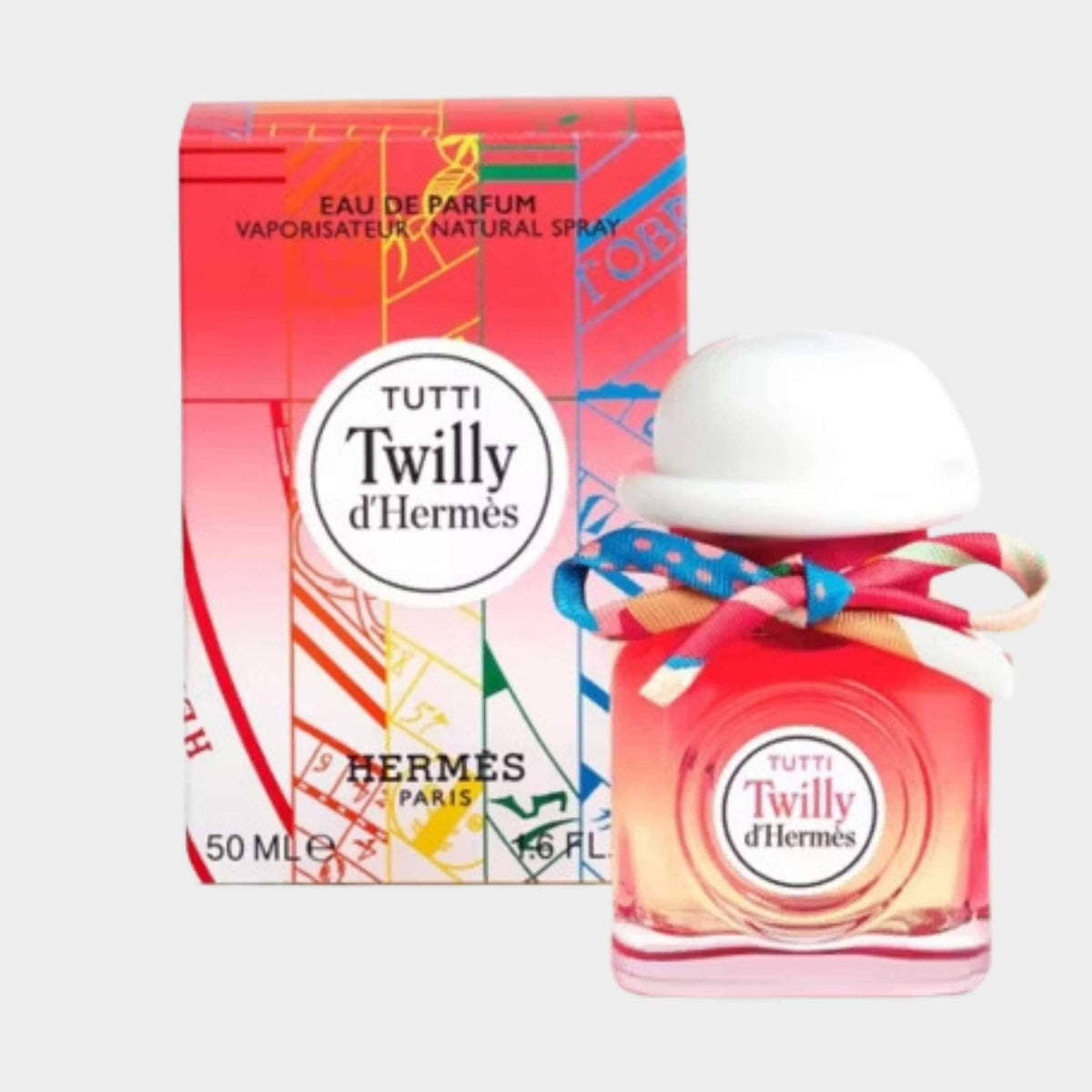 Twilly d'Hermès Tutti Eau de Parfum bottle with white bowler cap and colorful silk ribbon displayed next to its vibrant retail packaging box.