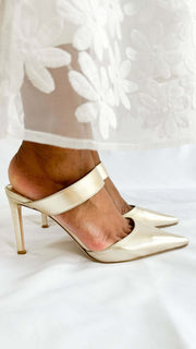Back profile view on foot highlighting the 85mm stiletto heel and thick metallic gold ankle strap of the Jimmy Choo Cheri pump.