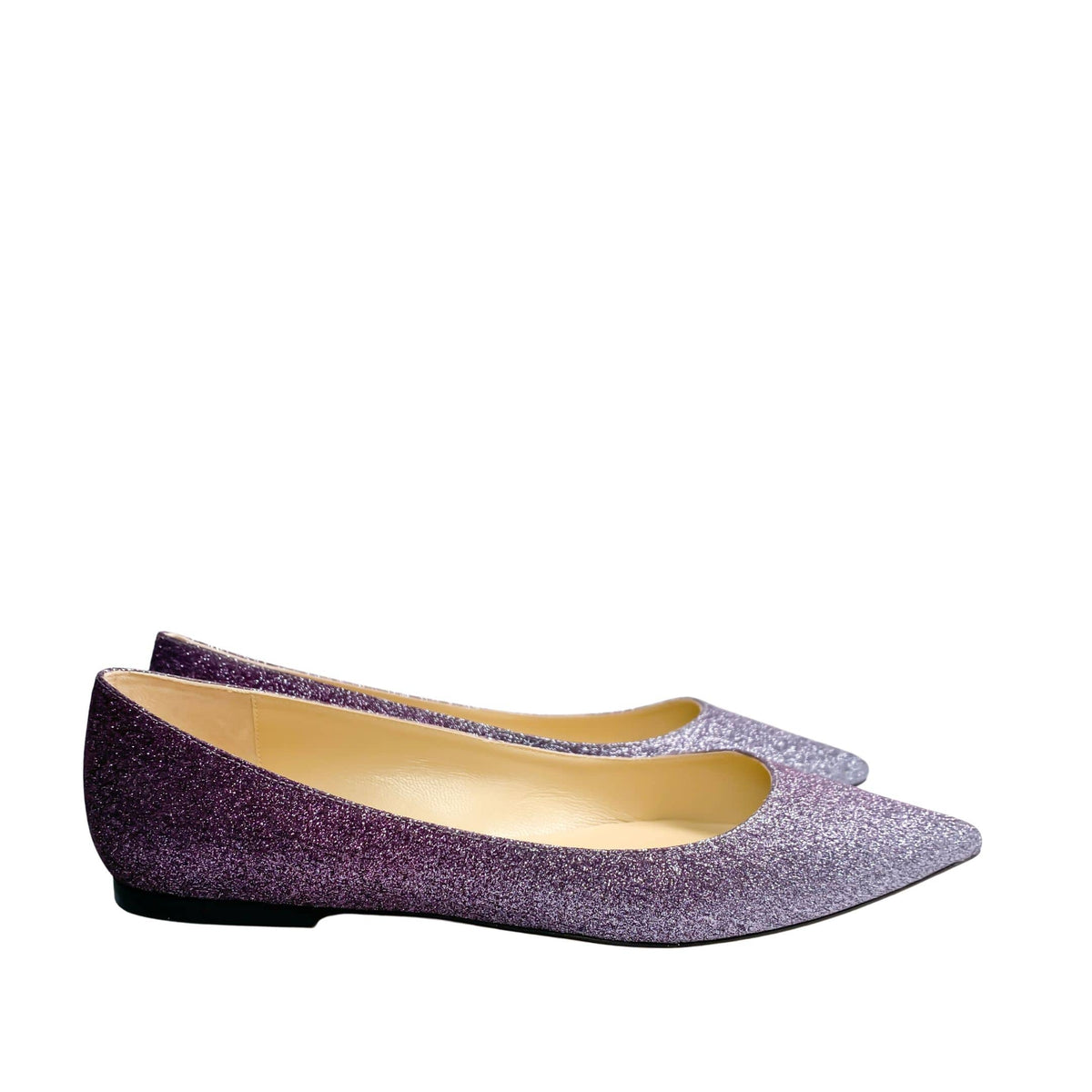 A level, elongated side profile of both Jimmy Choo shoes nested together, emphasizing the ultra-low sleekness of the flat heel design.
