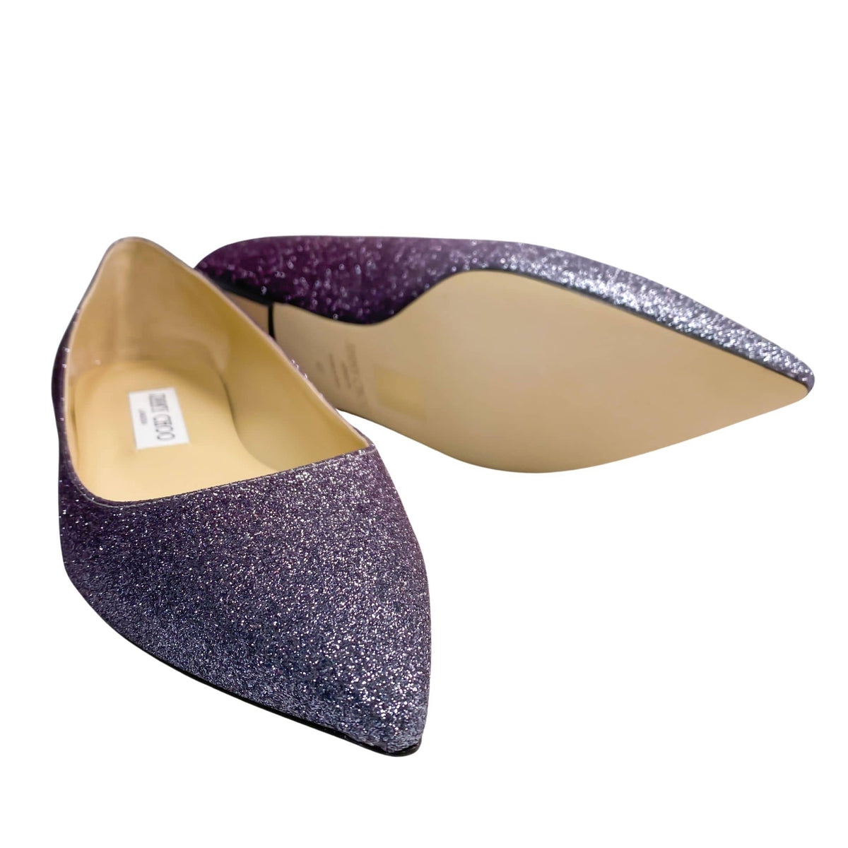 A dynamic composition showing the shoes turned to display their underside structure, noting the smooth finish and fine alignment of the stacked sole.