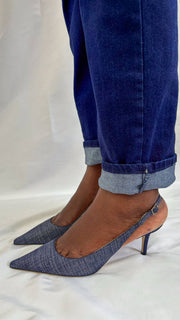 Side profile view on foot highlighting the comfortable 65mm mid heel height on Jimmy Choo Harper denim pumps.