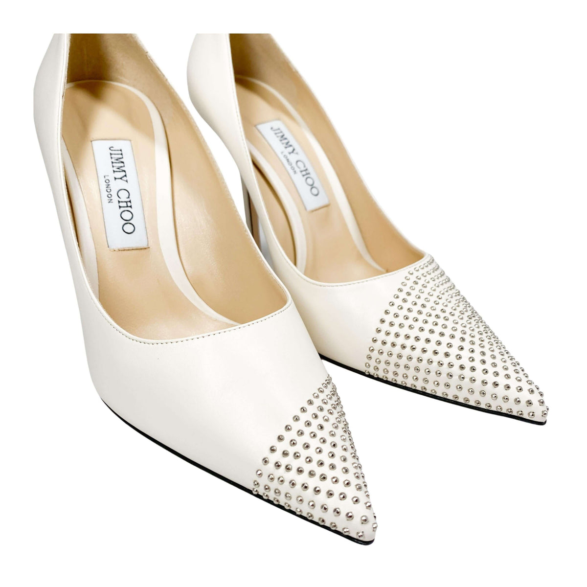 Angled studio shot of Jimmy Choo Love 100 off-white studded luxury dress heels displayed on a clean background.