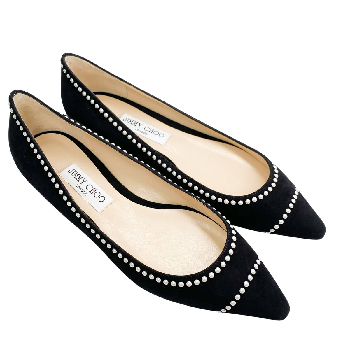 Three-quarter studio view of a pair of Jimmy Choo Romy black suede dress flats with pearl trim.