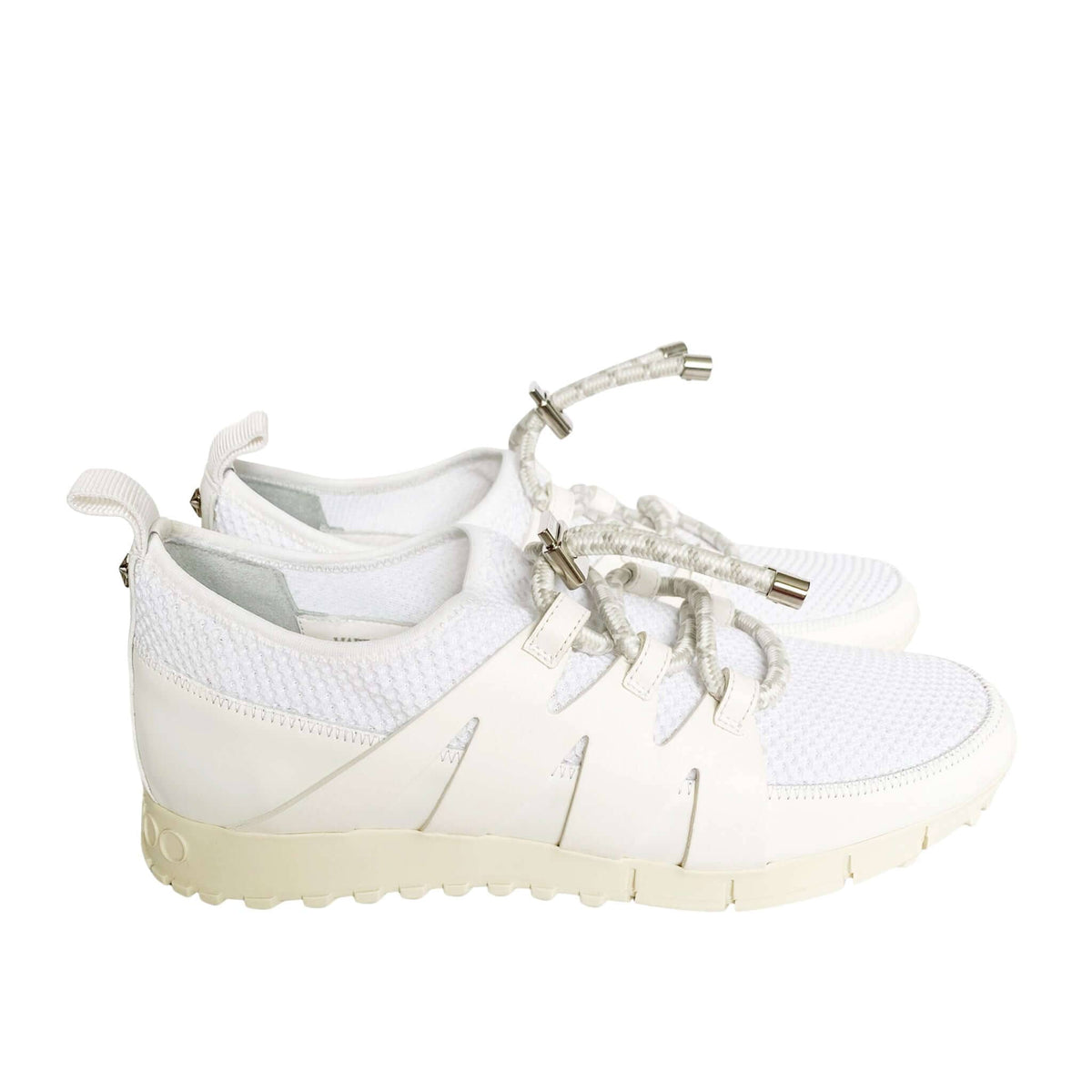 Side profile view of white Jimmy Choo Nija trainer displaying mesh upper texture and flexible rubber sole.
