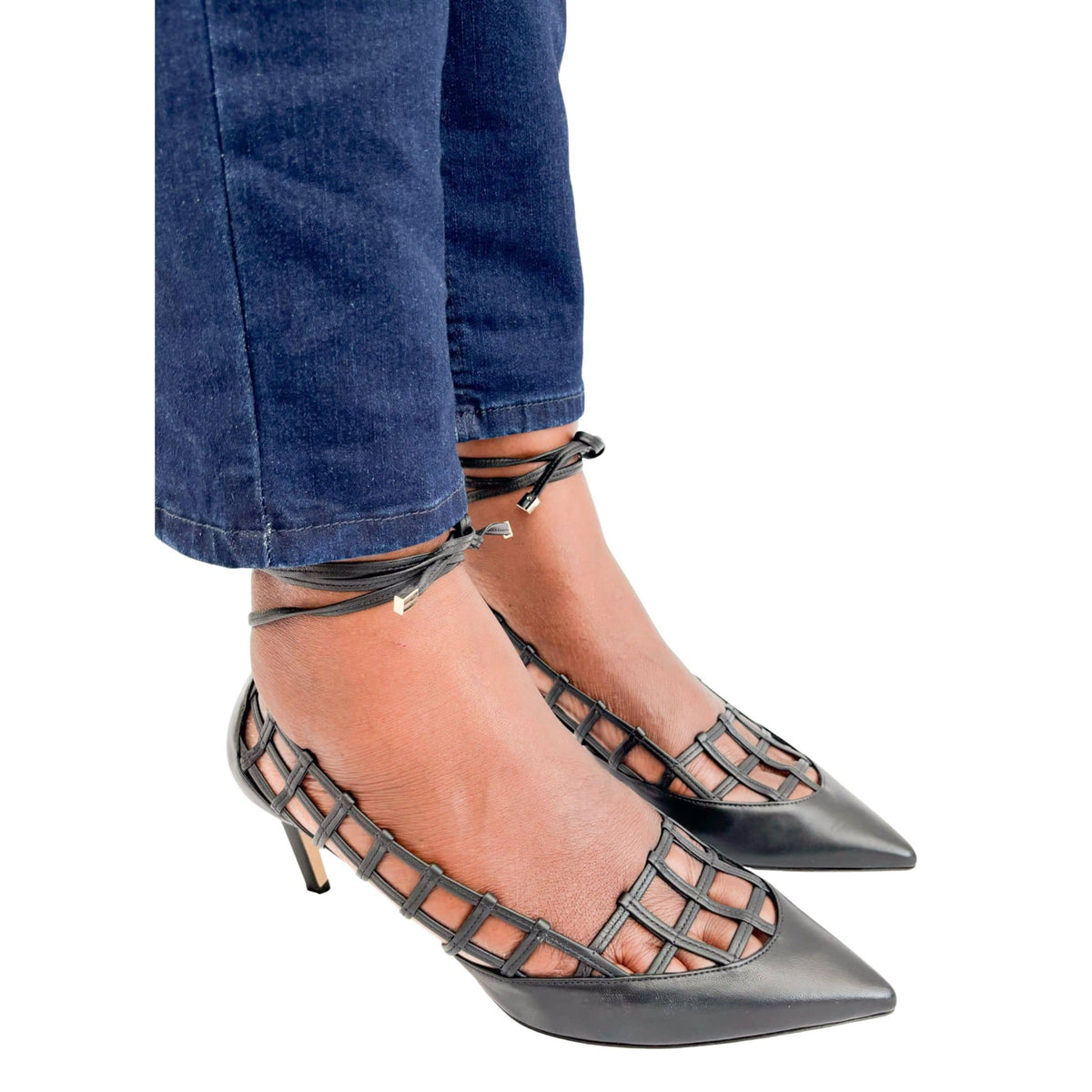Jimmy Choo Soraya 65 black leather caged heels styled on foot with dark wash denim jeans.