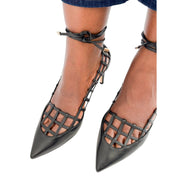 Side profile view on foot of Jimmy Choo Soraya 65 black leather caged pumps displaying the ankle ties and low heel curve.