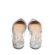 Overhead top-down view of a pair of Jimmy Choo Gemista silver glitter flats highlighting the pointed toe box and beige leather lining.