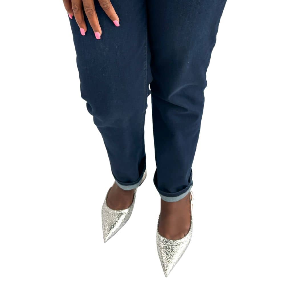 Front perspective view of Jimmy Choo Gemista silver glitter slingback flats styled on foot with dark wash denim jeans.