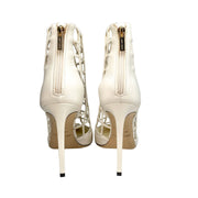 Rear view highlighting the gold back zip entry and 100mm stiletto heel design on the Jimmy Choo Sheldon white leather pumps.