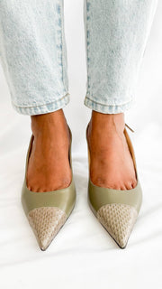 A head-on wearing perspective of the pointed-toe Jimmy Choo pumps, illustrating the clean, symmetrical line of the toe box and the texturing on the front.