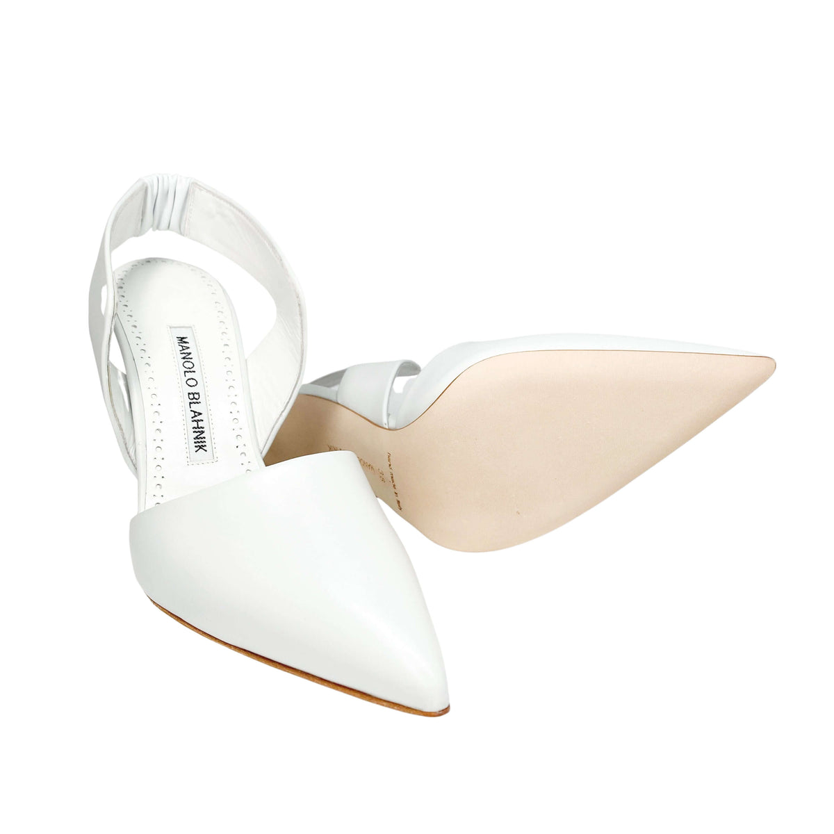 Side profile view of a single white Manolo Blahnik Meana pump showcasing the clean architectural lines and high stiletto heel.
