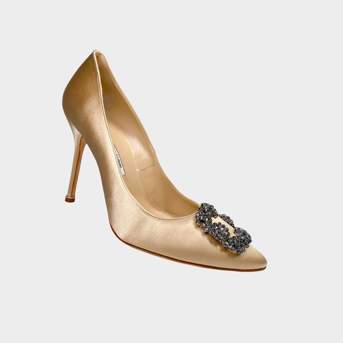 Side profile view of Manolo Blahnik Hangisi 105 champagne satin pump featuring a sparkling square crystal brooch buckle and 105mm stiletto heel.