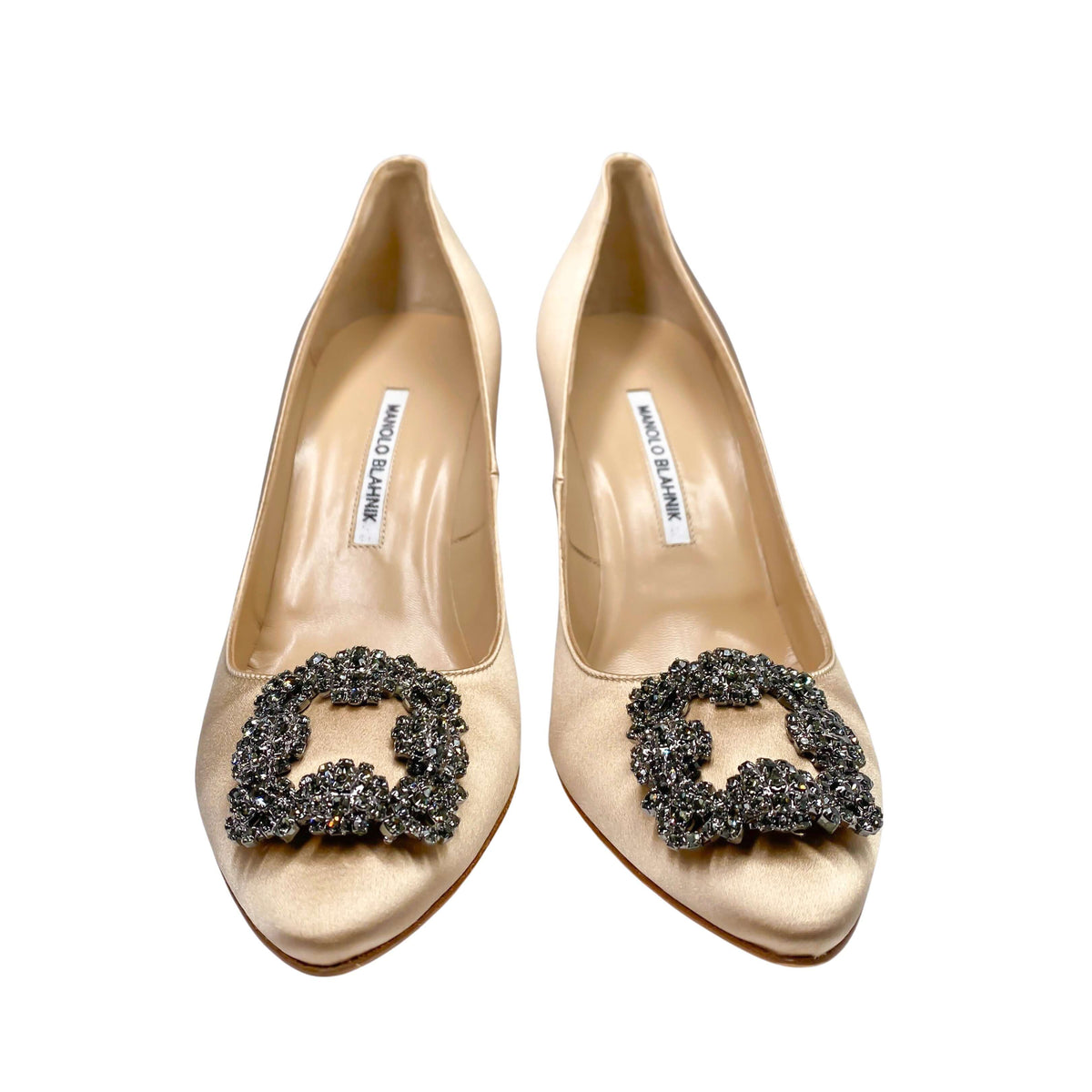 Direct front pair view of Manolo Blahnik Hangisi 105 champagne satin heels displayed on a clean studio background.