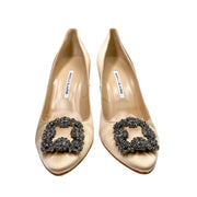 Direct front pair view of Manolo Blahnik Hangisi 105 champagne satin heels displayed on a clean studio background.