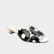 Side profile view of Manolo Blahnik Lottara 30 slide sandals in black and white leather featuring floral cutout overlays and a 30mm low block heel.