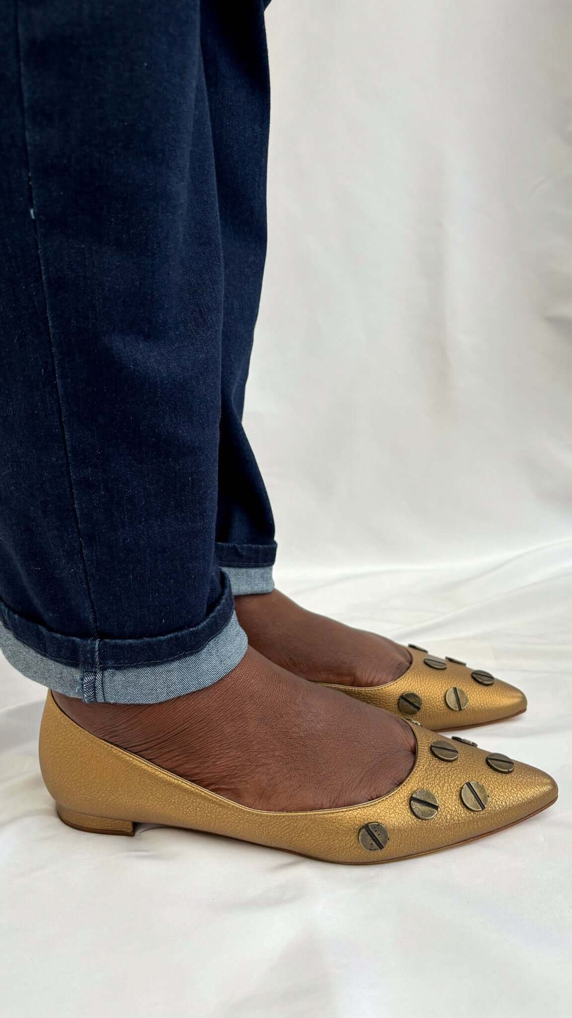 Side view of the Manolo Blahnik Panunzia metallic bronze pointed-toe flat shoe worn on-foot.