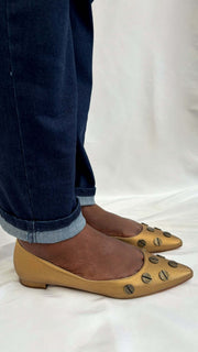 Side view of the Manolo Blahnik Panunzia metallic bronze pointed-toe flat shoe worn on-foot.