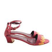 Studio side perspective of a single Manolo Blahnik Lochpri red canvas sandal highlighting the low block-style kitten heel and open toe.