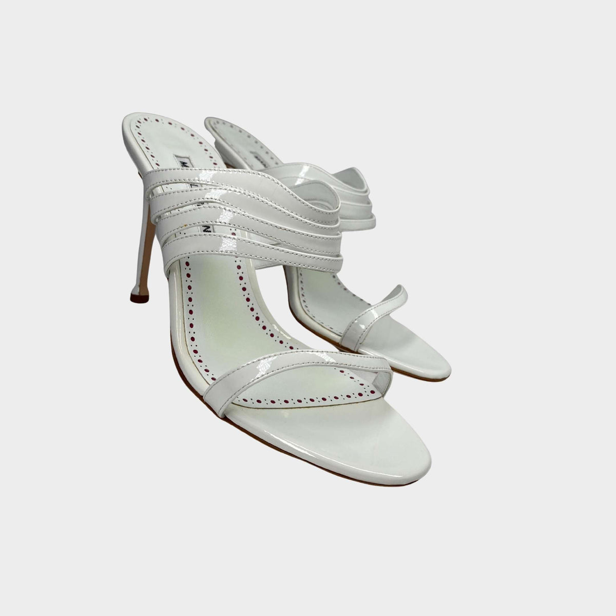 Manolo Blahnik Curatora 105 white leather wedding sandals featuring curved multi-strap front ribbons and a stiletto heel.