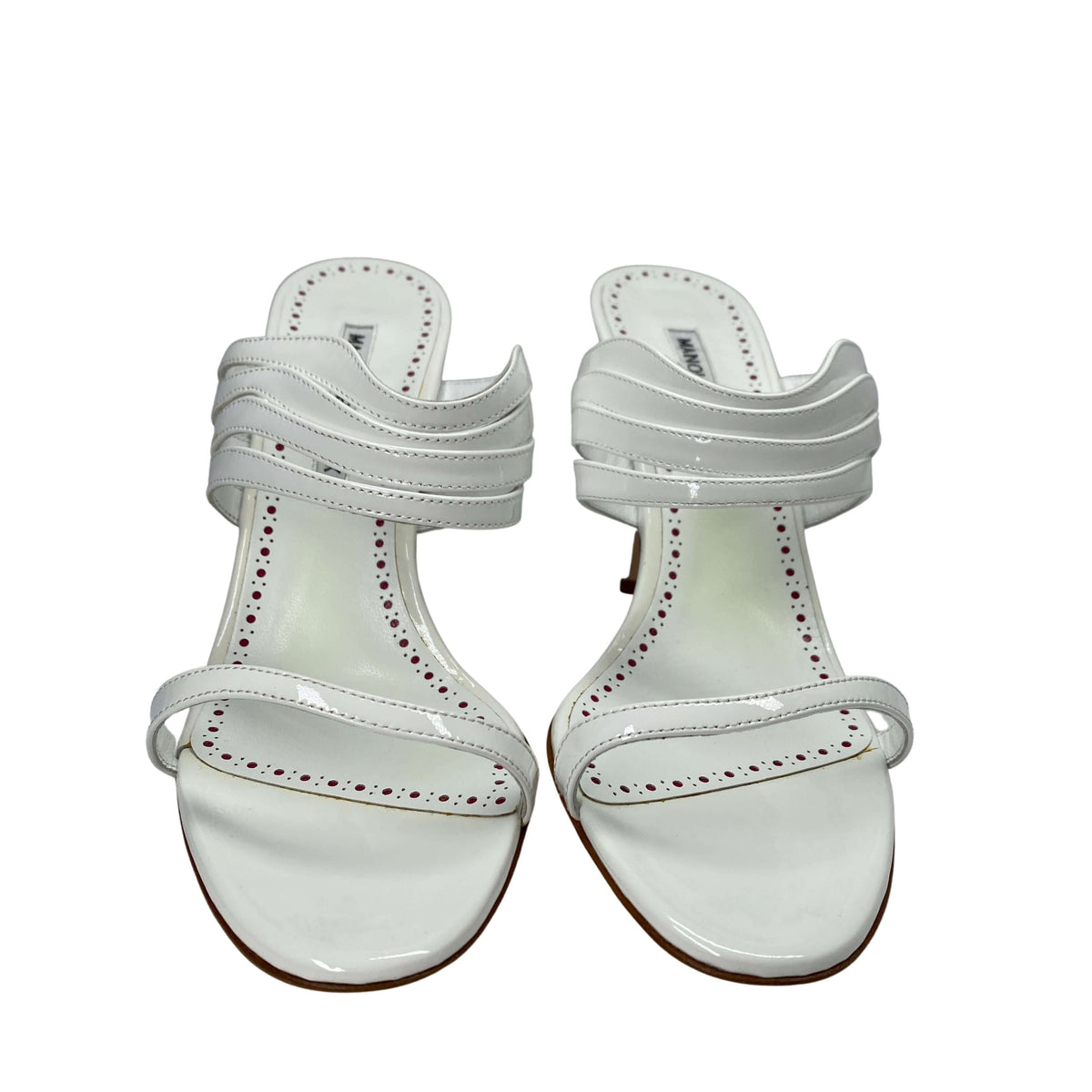Front view of a pair of white Manolo Blahnik Curatora heeled sandals highlighting the layered strap design.