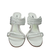 Front view of a pair of white Manolo Blahnik Curatora heeled sandals highlighting the layered strap design.