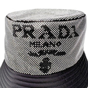 Close-up view of silver crystal Prada Milano logo detail on black nylon luxury bucket hat