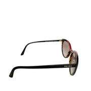 Side angle view of Prada tortoise shell sunglasses showing red accent detail and sleek temple design