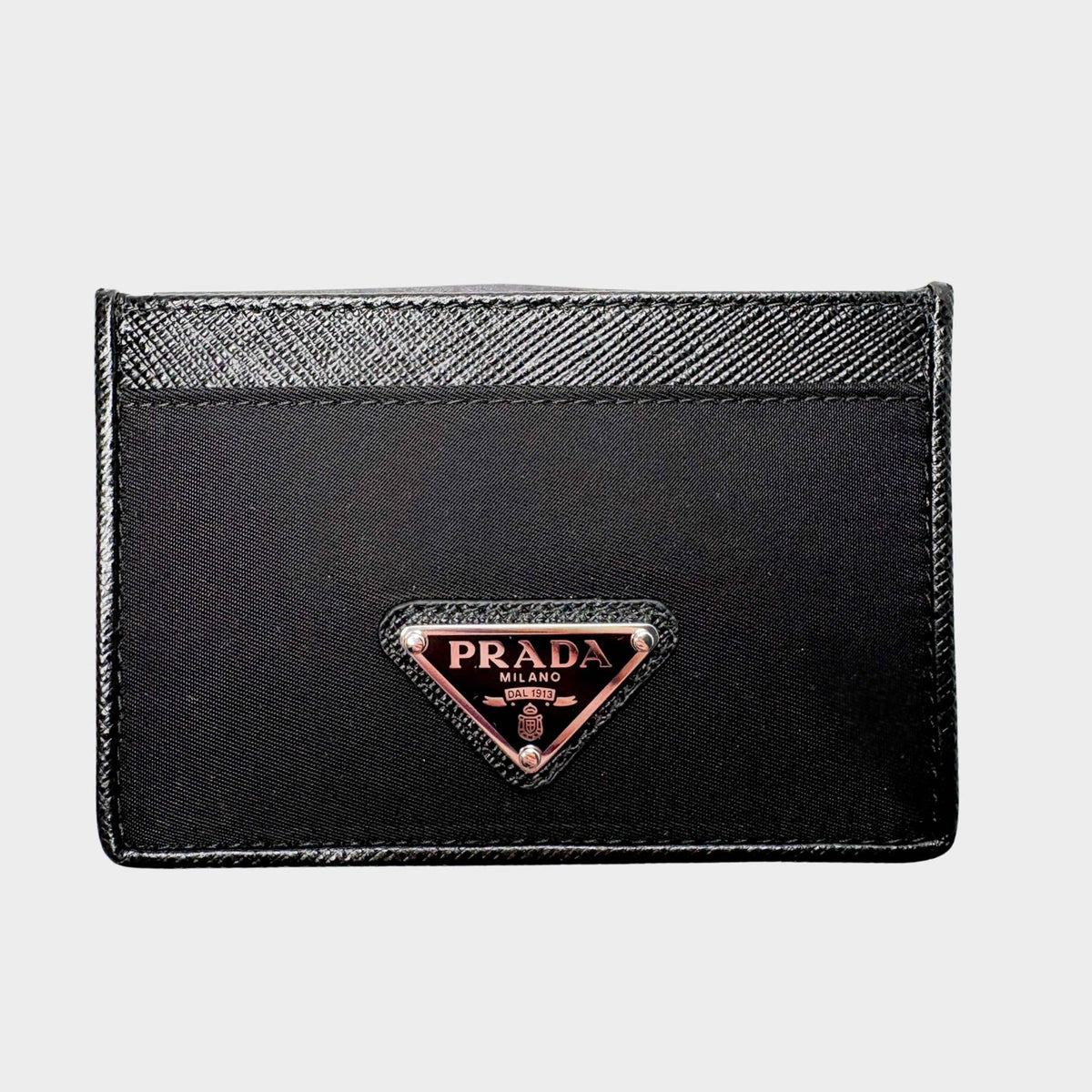 Front view of black Prada card holder in Saffiano leather and nylon featuring iconic triangular enamel logo