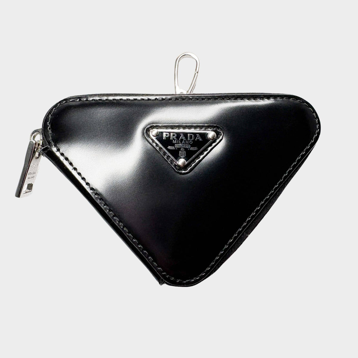 Front view of black Prada Spazzolato leather triangle coin pouch bag charm with iconic enameled metal logo