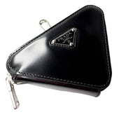 Side profile view of black Prada Spazzolato triangle leather bag charm keyring pouch