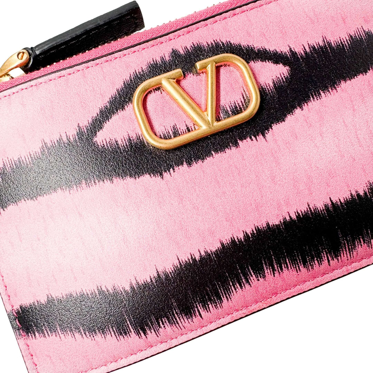 Three-quarter angled view of the striped Valentino V-Logo coin purse, highlighting the zip-around closure and gold-tone zipper detailing.