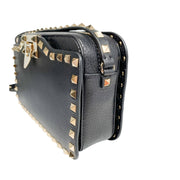 Angled side view of black leather Valentino camera bag showcasing side stud layout and depth.