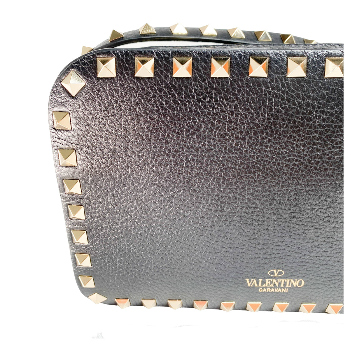 Frontal view of black Valentino Rockstud camera bag showing the gold clasp and perimeter stud border.