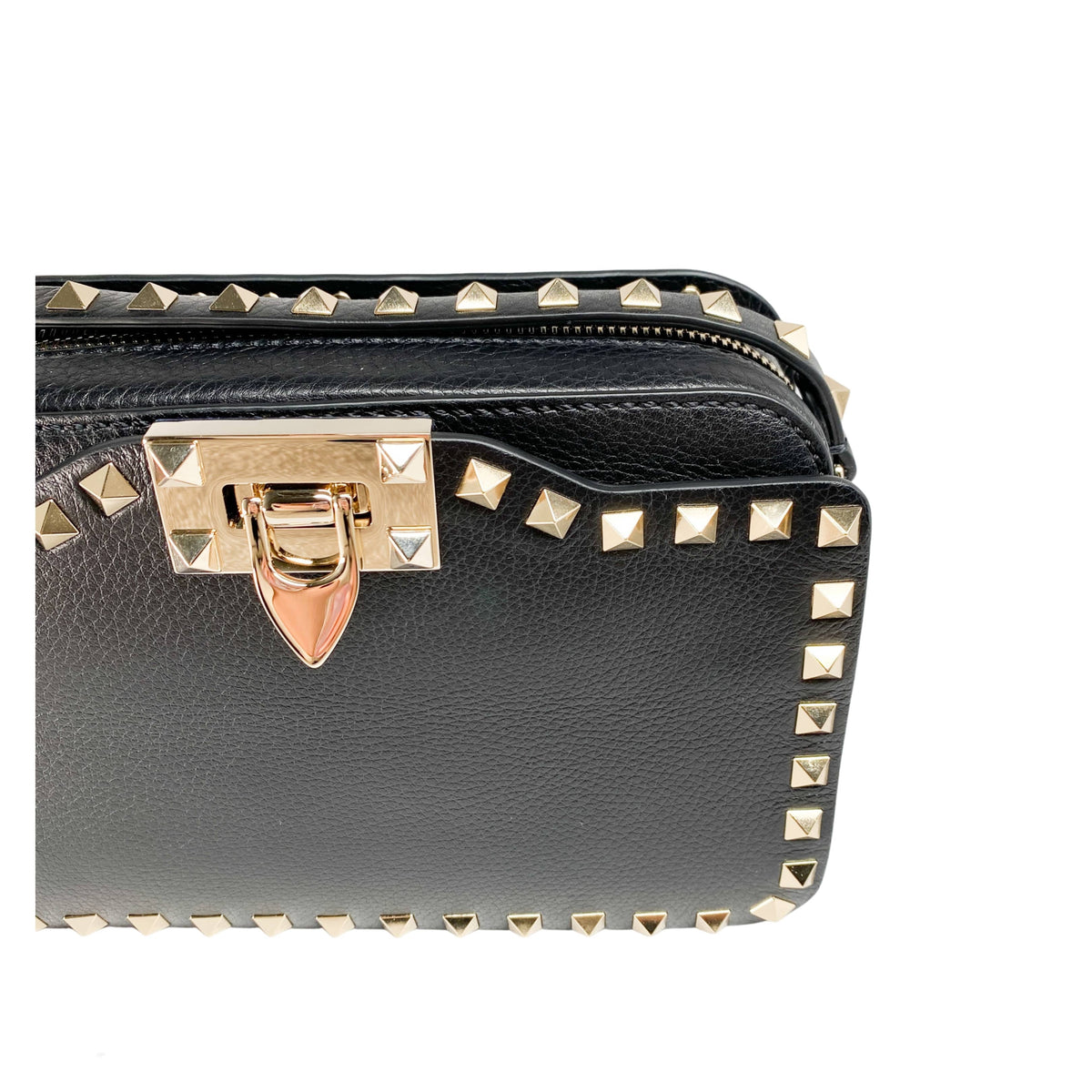 Close-up view of the gold-tone metal flip clasp and stud detailing on the black Valentino bag.