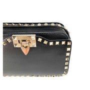 Close-up view of the gold-tone metal flip clasp and stud detailing on the black Valentino bag.