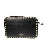 Back view of black leather Valentino Rockstud camera bag showing gold logo stamp and zipper closure.