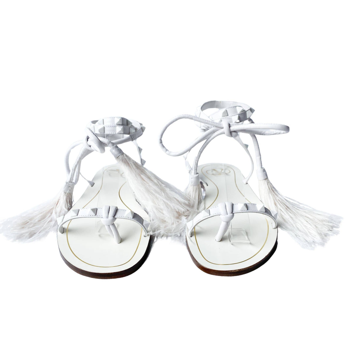 Front view of a pair of Valentino Garavani Flair white leather lace-up sandals with white feathers and signature studs.