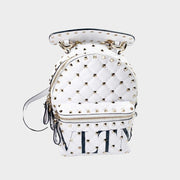 Valentino Rockstud backpack in white quilted leather featuring gold studs and black printed logo.