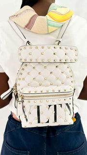 Model carrying the white Valentino Rockstud mini backpack on her back using dual shoulder straps.