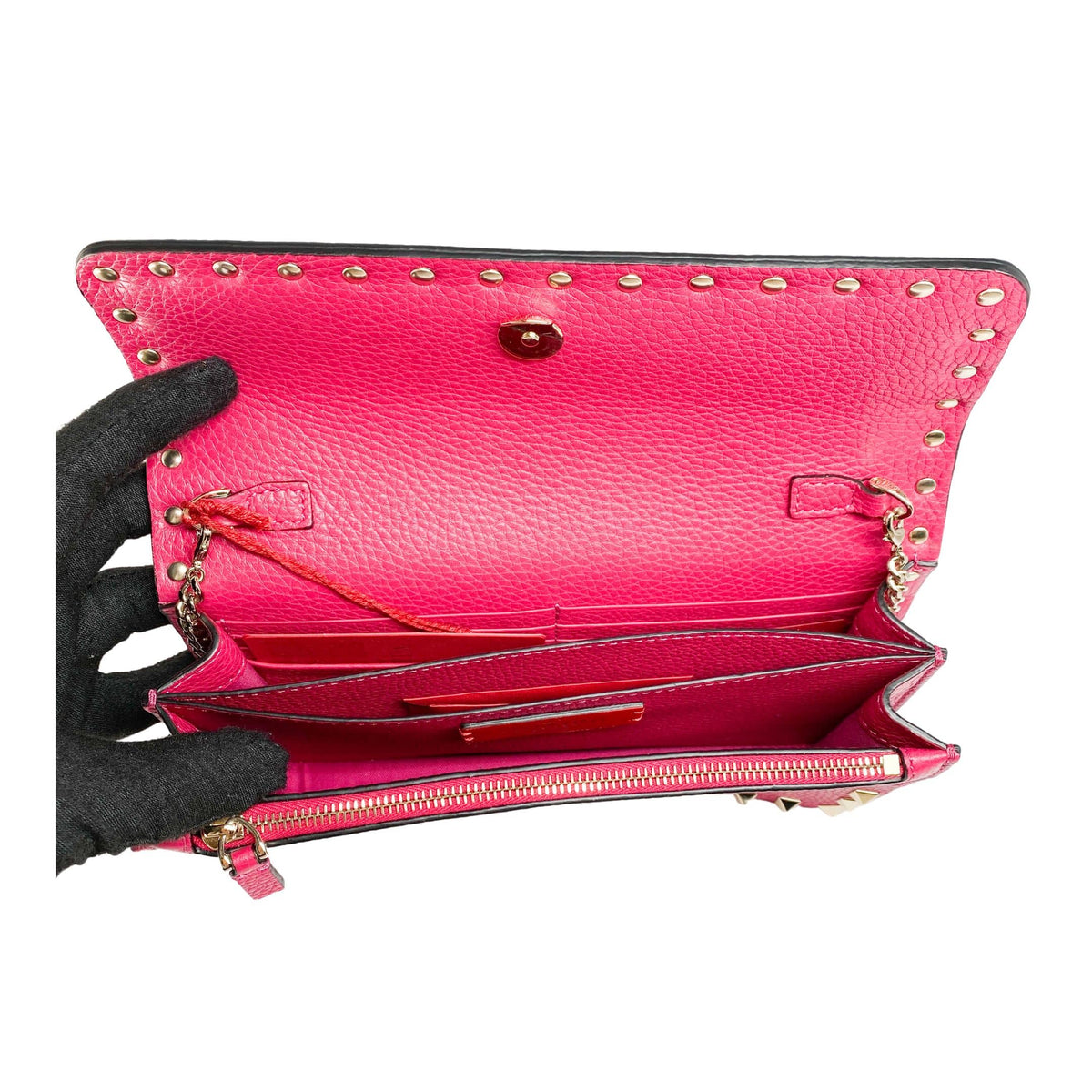 Inside view of the hot pink Valentino Rockstud flap clutch displaying the open main compartment and inner lining.