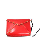 Front perspective view of the red Valentino Rockstud handbag highlighting the gold pyramid studs and black edge piping.
