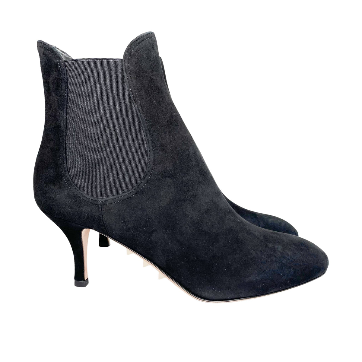 Angled side profile of black suede Valentino Beatle ankle boot showing almond toe and curved heel line.