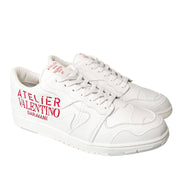 Angled front view of white Valentino Atelier trainers showing lace-up closure and toe cap.