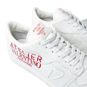 Close-up angled view of the heel and side logo print on white Valentino Garavani low-tops.