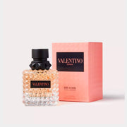 Valentino Born in Roma Coral Fantasy Eau de Parfum studded glass bottle displayed next to its original coral pink box packaging.
