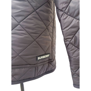 Close-up of Burberry logo detail on Dalry quilted jacket in black